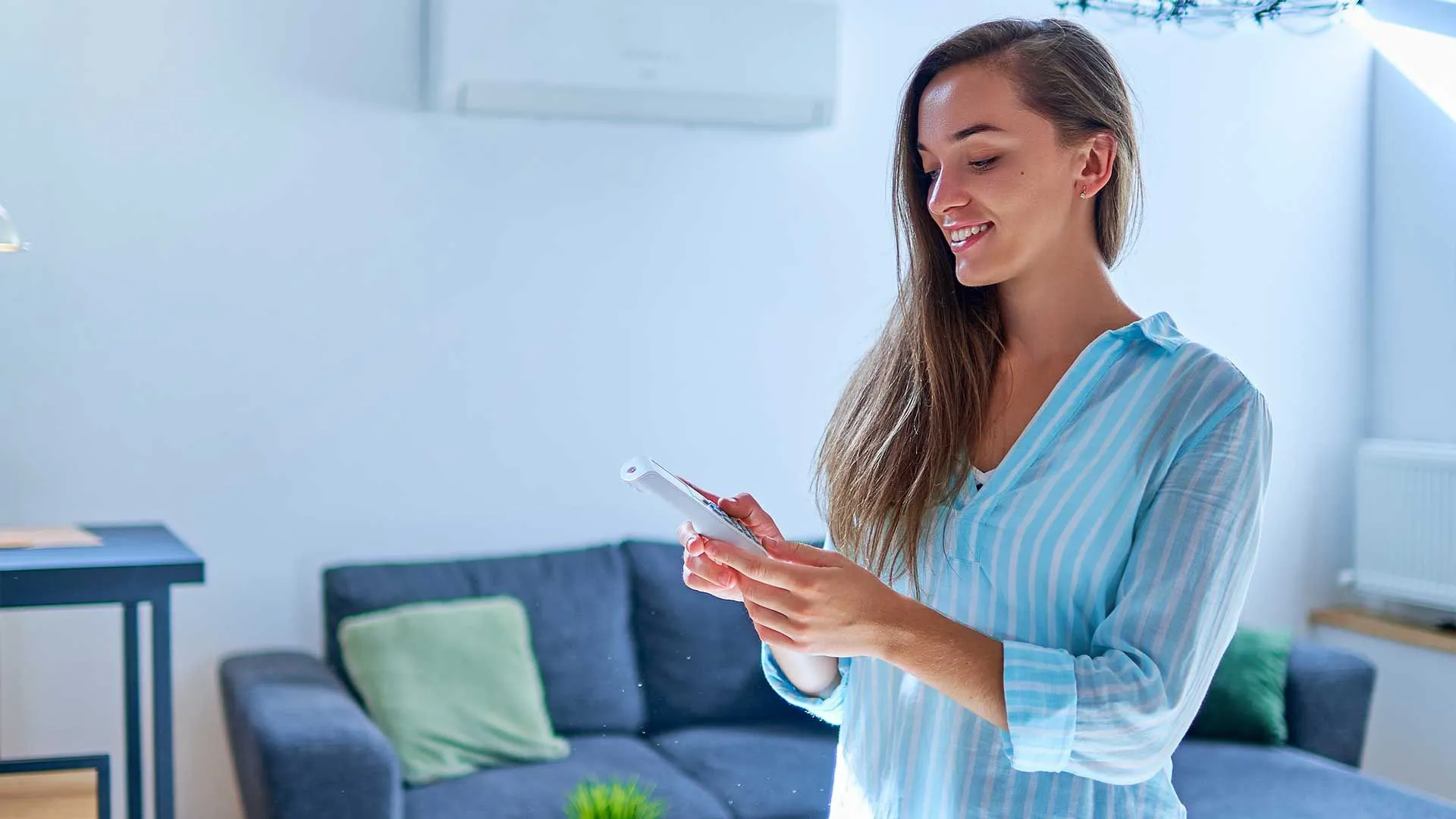 Person adjusting a wall thermostat to improve indoor air quality at home.